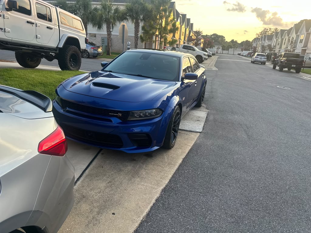 Blue Dodge Charger parked at sunset after a detail