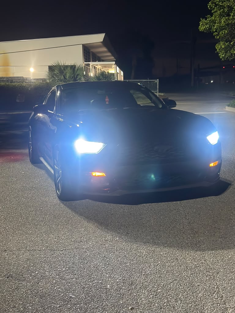 Car detailed after dark, headlights on
